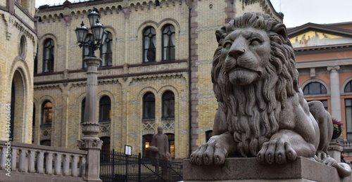 detail lion statue in front of parliament of Norway back ground with yellow  building