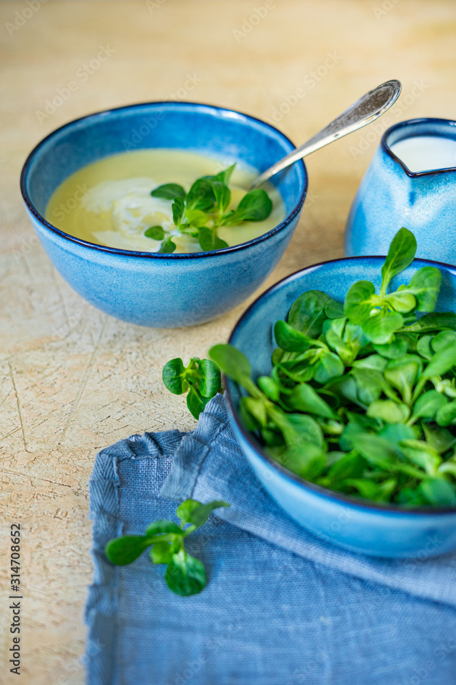 Homemade puree soup from fresh zucchini and yang spinach on light yellow background. Healthy and diet food menu. Vertical banner Homemade puree soup from fresh zucchini and yang spinach on light yellow background. Healthy and diet food menu. Vertical banner
