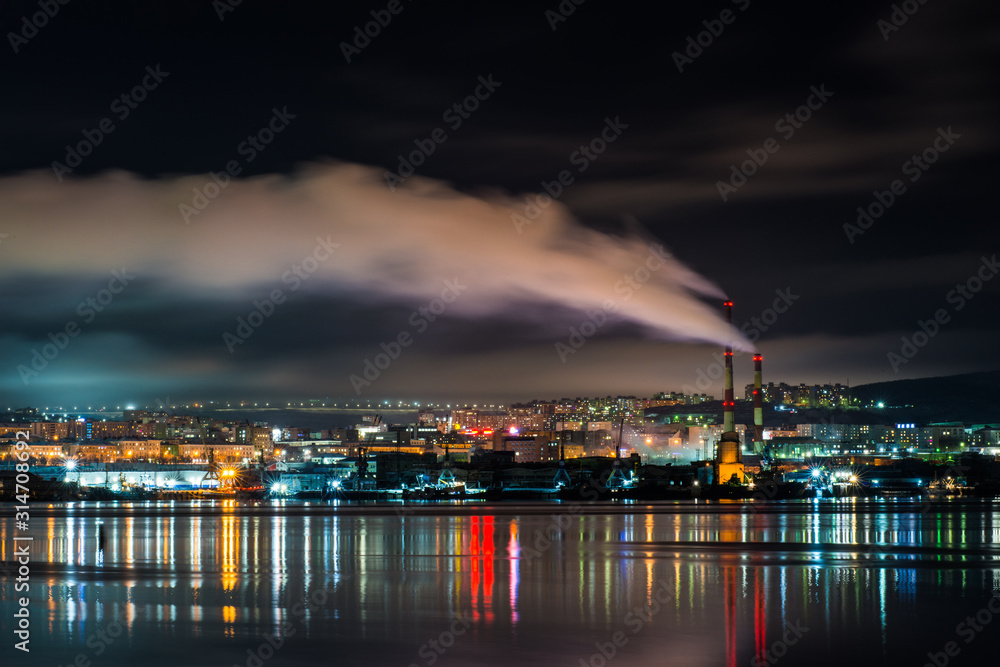 night Murmansk, city lights reflected in the Bay and the ships standing in the port