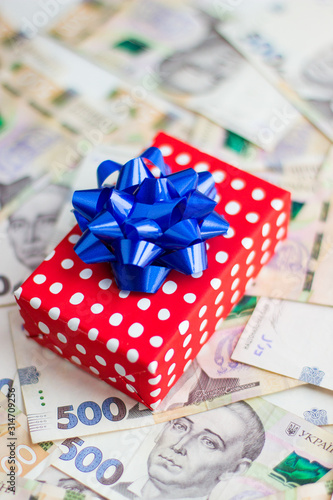 gift box with a bow lies on paper money, Ukrainian hryvnia