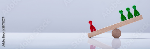 Pawns Figures On Wooden Seesaw photo