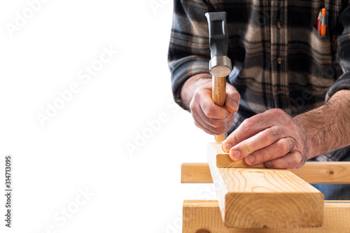 Close-up. Carpenter with hammer and nails fixes a wooden board. Construction industry, do it yourself. White background.