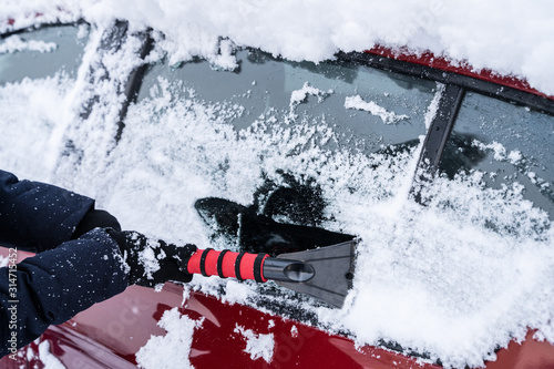 Woman Cleaning Car From Snow