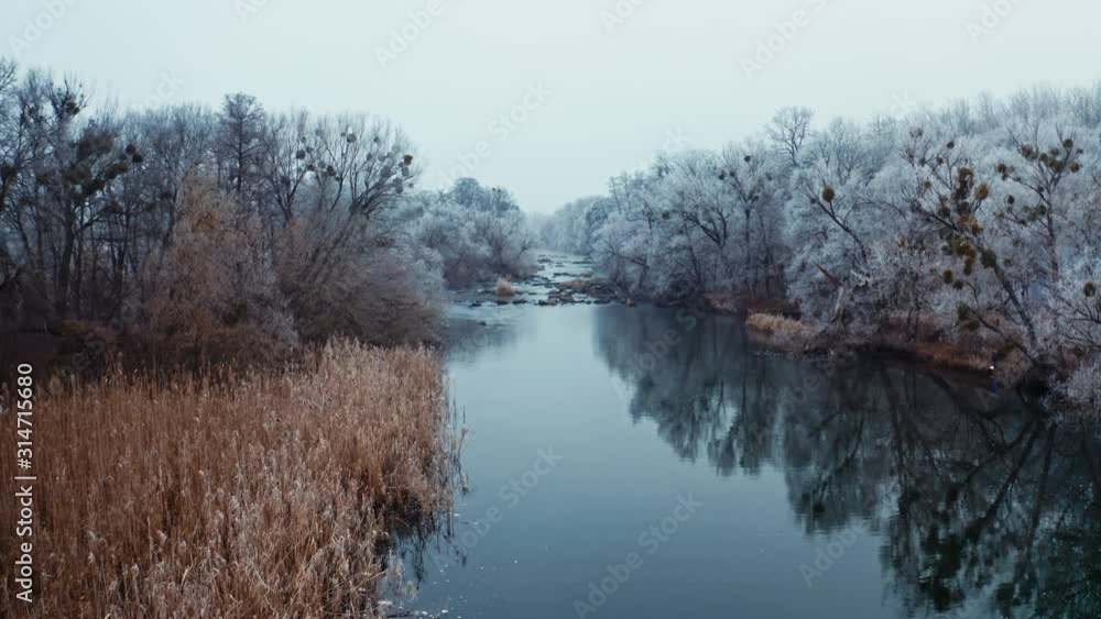 Forest and river wild landscape. Aerial view of forest with river during winter Forest and river wild landscape. Aerial view of forest with river during winter