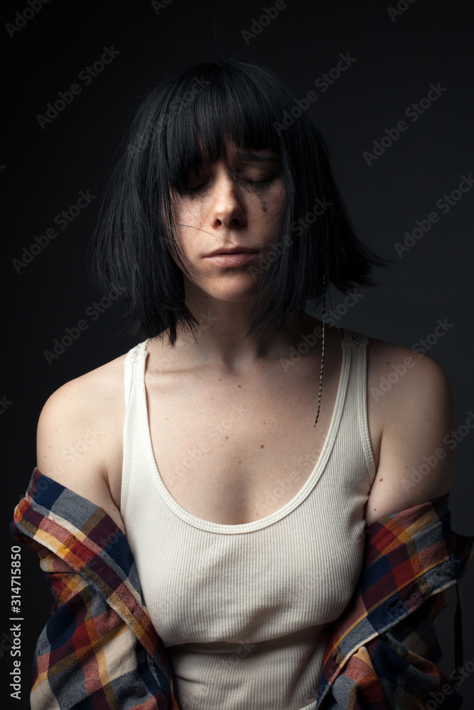 Portrait of crying young woman in studio. Portrait of crying young woman in studio.