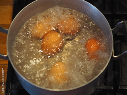 Homemade food. Chicken eggs are cooked in a saucepan over a fire. Preparing a filling for pies.