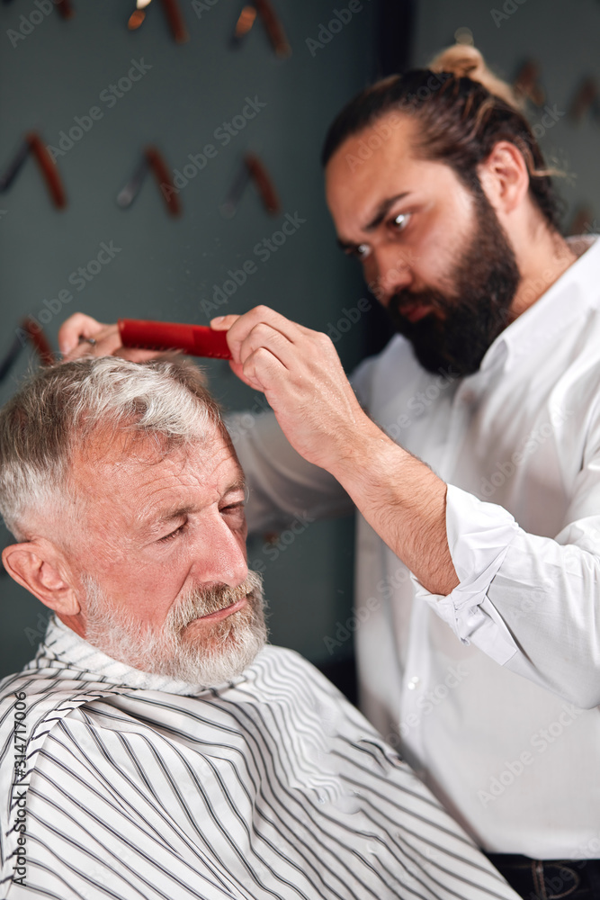 Fototapeta premium professional talented barber making haircut, close up photo