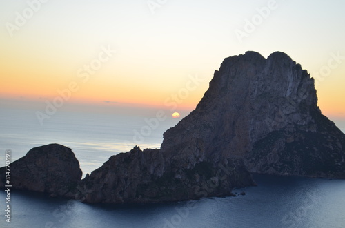 sol despidiendose en el horizonte del mar mediterraneo entre los islotes de ibiza