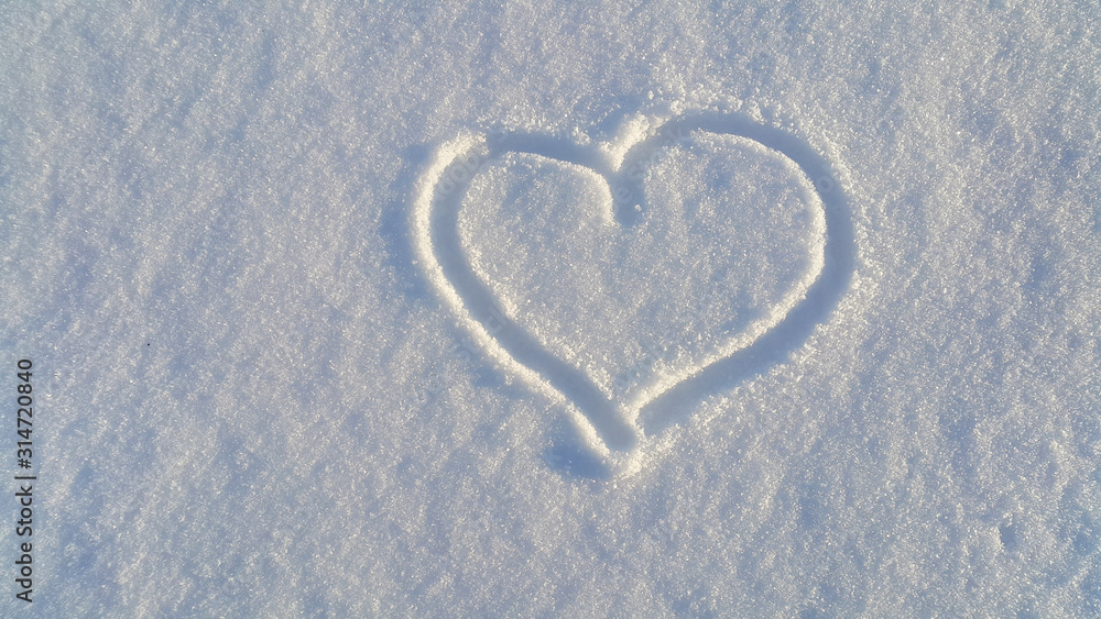 Draw of heart on the white snow