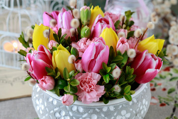 Woman shows how to make beautiful floral arrangement with tulip and carnation flowers