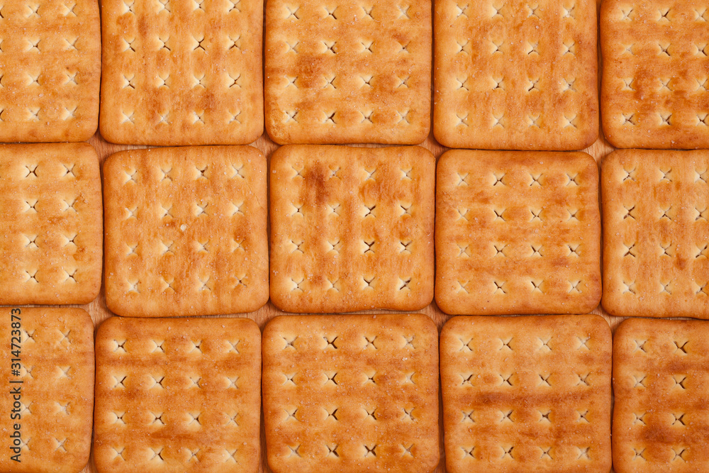 Background of square salty crackers. Top view Background of square salty crackers. Top view