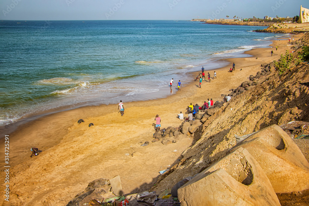 Obraz premium Dakar, Senegal- April 24 2019: Men playing football on the beach near Dakar city in Africa. It is the capital city of Senegal.