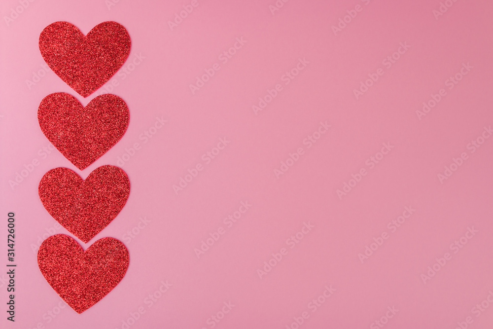 four red paper hearts arranged in a line on the background