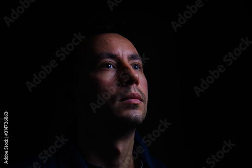 portrait of a young guy in low key on a black background
