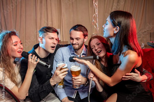 five happy people singing and drinking in karaoke, spend free time in day-off, enjoy pastime in karaoke
