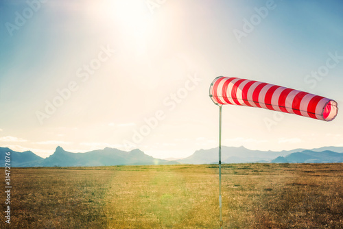 Φωτογραφία Striped weather vane against blue sky