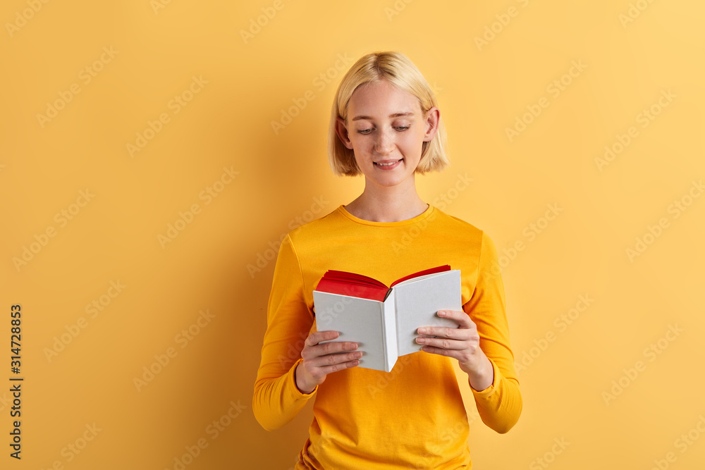 cheerful beautiful woman enjoying reading book, lifestyle, interest, free time, spare time, isolaated yellow background, studio shot cheerful beautiful woman enjoying reading book, lifestyle, interest, free time, spare time, isolaated yellow background, studio shot