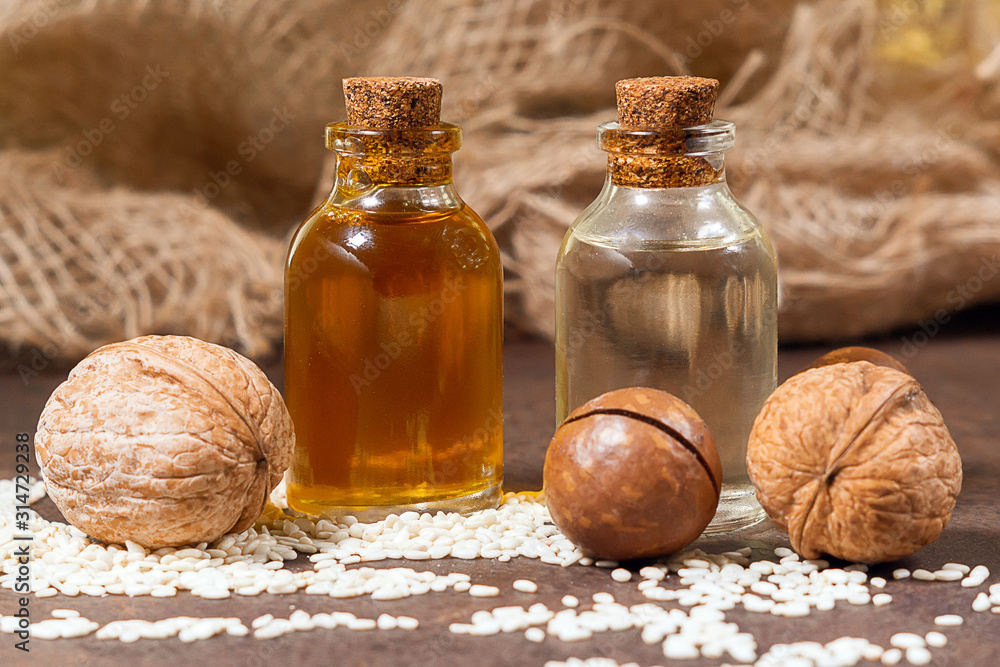 cosmetic oil from nuts walnuts, macadamia, sesame. still life, retro style, healthy foods, diet cosmetic oil from nuts walnuts, macadamia, sesame. still life, retro style, healthy foods, diet