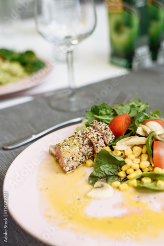 Salad of greens, canned corn and fried tuna in sesame seeds. Recipe for an expensive fish