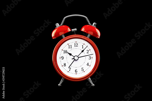 Red alarm clock close-up isolated on dark background.