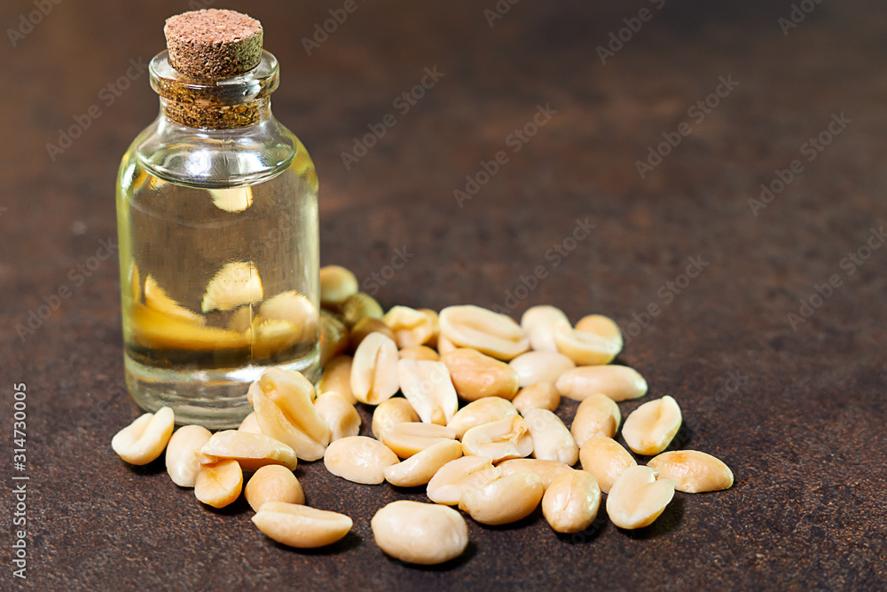 Peanut oil on a brown background is used in folk medicine, cosmetology, as well as for cooking various dishes Peanut oil on a brown background is used in folk medicine, cosmetology, as well as for cooking various dishes