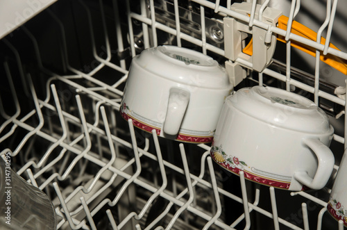 dirty cups inside a dishwasher