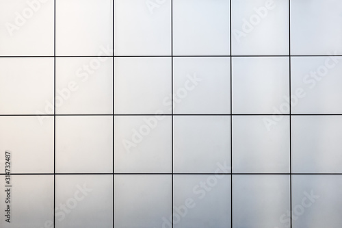 A view of a metal wall with square tiles.