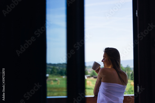 woman in white towel with a cup of coffee in the morning. back v Free Download woman in white towel with a cup of coffee in the morning. back v - GFXLoad