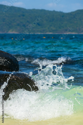 Wallpaper Mural Beautiful seascape. The wave breaks against stones and splashes of water fly away. Torontodigital.ca