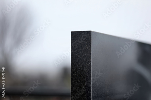 Black granite tombstone outdoors, closeup with space for text. Funeral ceremony