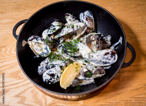 Mussels with garlic white sauce in a bowl. Restaurant