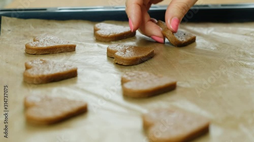 Woman making ginger cookies heart shaped for valentine day or christmas, close up photo