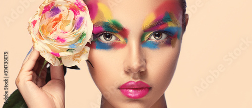Canvas Print Beautiful girl model with multi-colored paints on her face