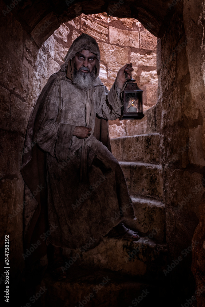 Ragged man, hanging around a passageway of a medieval city