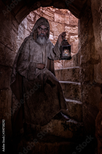 Ragged man  hanging around a passageway of a medieval city