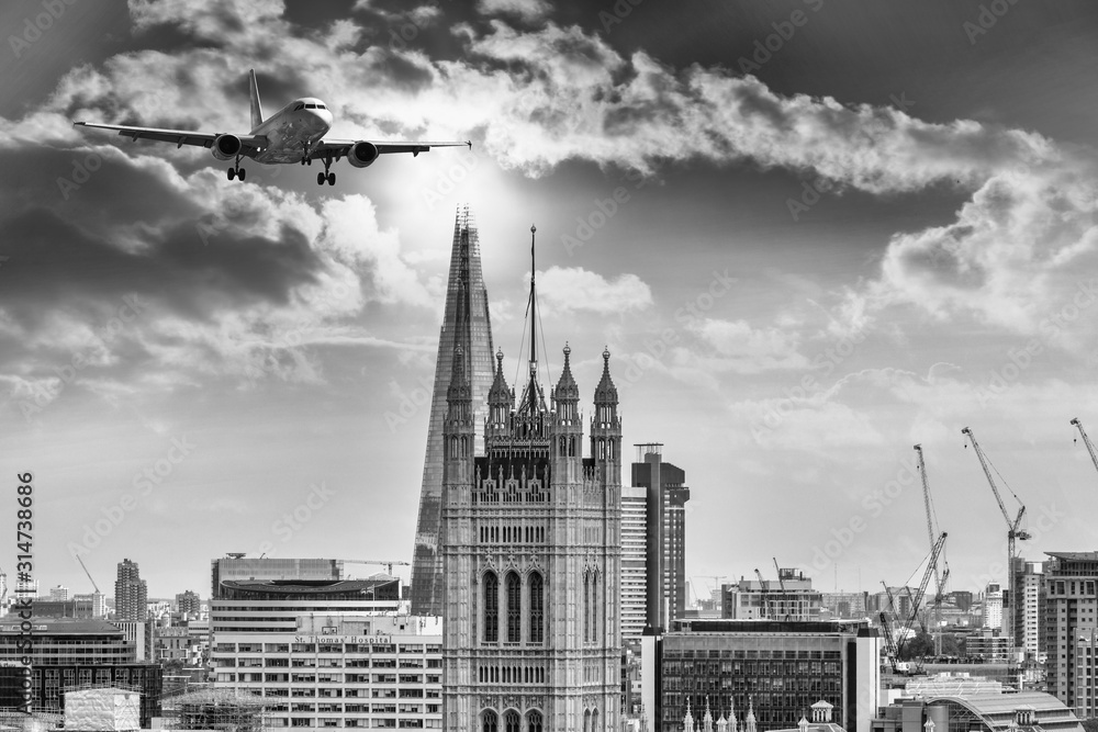 Airplane over new and old tower in London