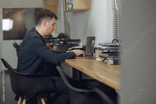 Handsome man in a black suit. Businessman working in a office