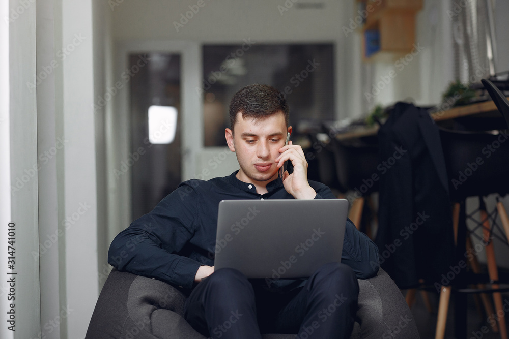 Handsome man in a black suit. Businessman working in a office Handsome man in a black suit. Businessman working in a office