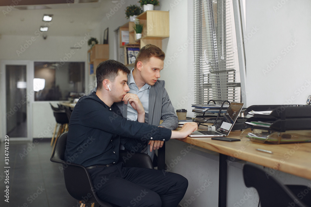 Handsome man in a black suit. Businessmen working in a office Handsome man in a black suit. Businessmen working in a office