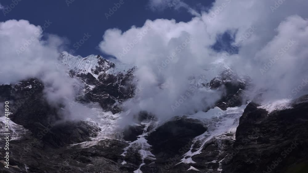 Tilt shot of Humantay Lake, Peru, on a sunny day with some white clouds in blue sky Tilt shot of Humantay Lake, Peru, on a sunny day with some white clouds in blue sky
