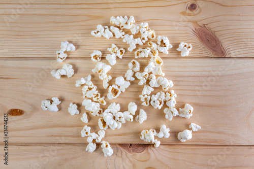 Heap of delicious popcorn, on wooden background . Scattered popcorn texture background.