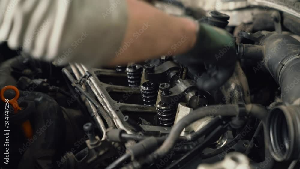 Car mechanic removing spark plug. Car mechanic removing spark plug.