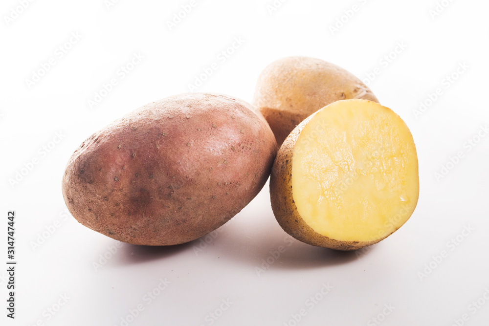 whole and cut potatoes on a white background whole and cut potatoes on a white background