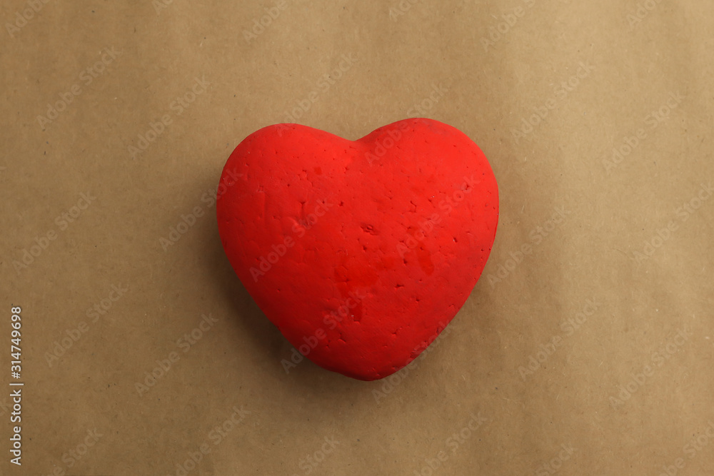 Red heart on brown paper background Red heart on brown paper background