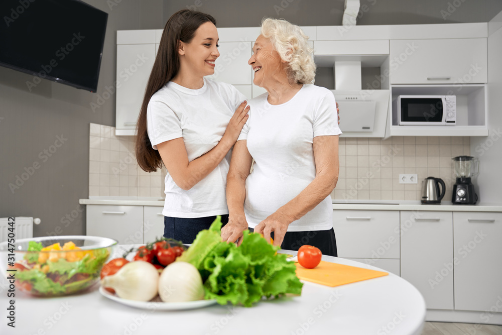 Happy grandmother and granddaughter cooking together. Happy grandmother and granddaughter cooking together.