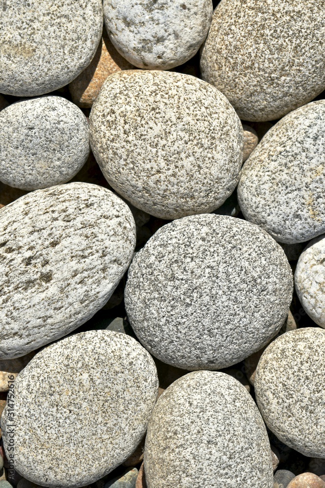 Naklejka premium Round large stones are stacked side by side in a vertical compositional background.