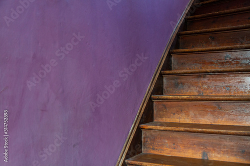 an old wooden staircase against a purple wall