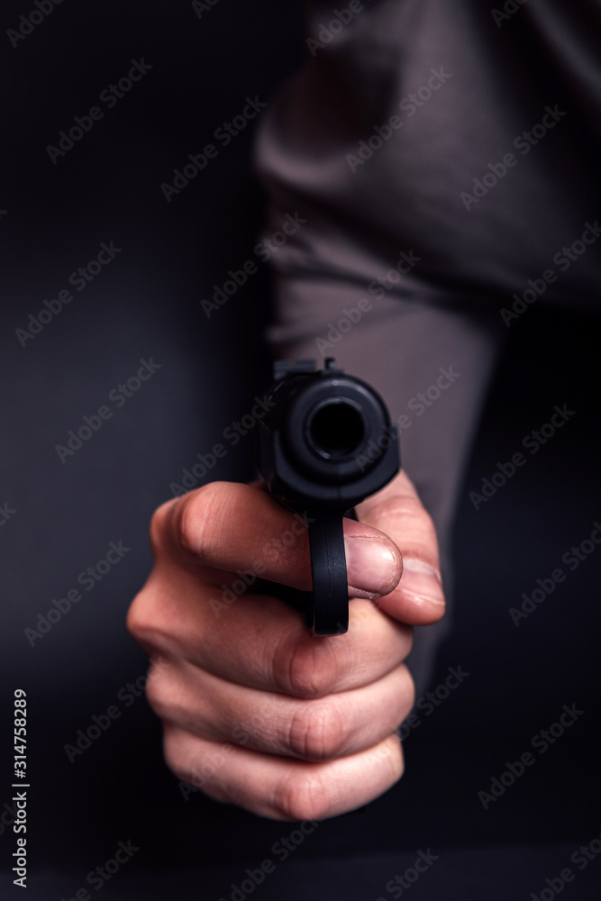 Male hand with gun isolated on black background. Man with a gun ready to shoot, focus on the weapon. Male hand with gun isolated on black background. Man with a gun ready to shoot, focus on the weapon.