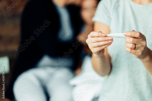 closeup of woman holding thermometer, checking temperature at home
