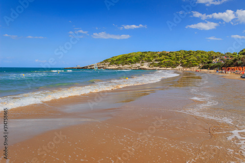 Apulia beach  Bay of Sfinale  between Peschici and Vieste  with an ancient Torre Saracena  typical lookout tower of the coast of Gargano  Italy.